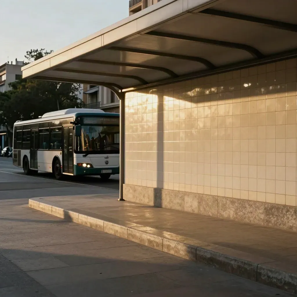 Autobús urbano entrando en una estación luminosa de Valencia con cerámica clara y luz dorada.